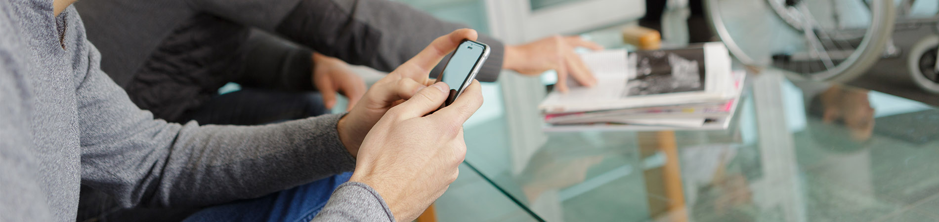 A young male patient utilizing digital check-ins at an appointment on his cellular device.