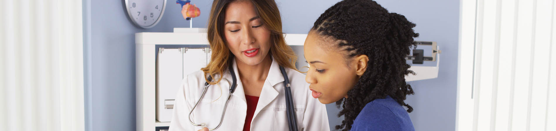 A doctor providing patient education to a patient in an exam room.