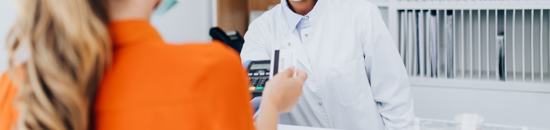 a woman using a payment processor to make a payment at a medical practice with a female practitioner