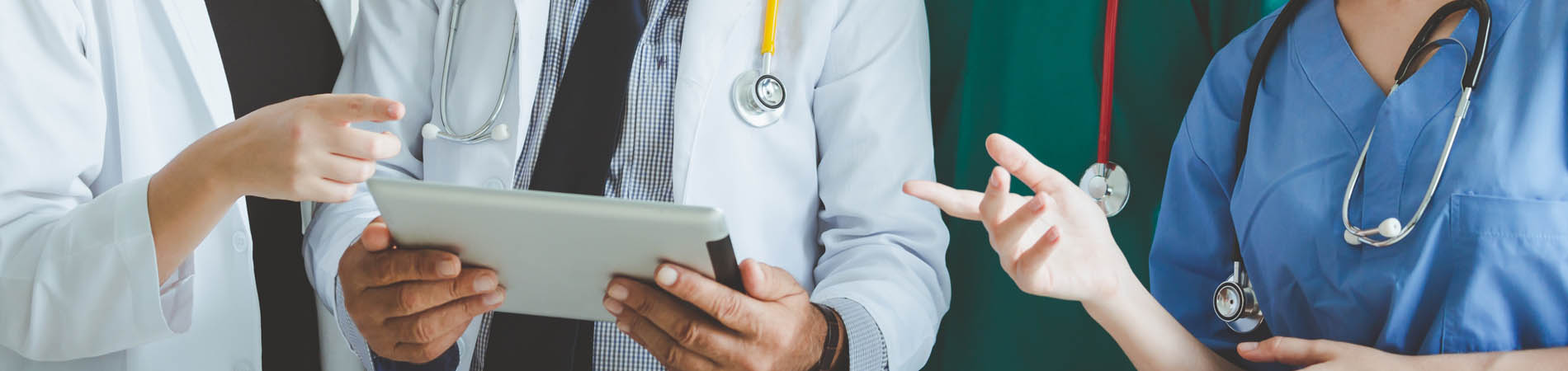 Group of doctors with tablet on white background