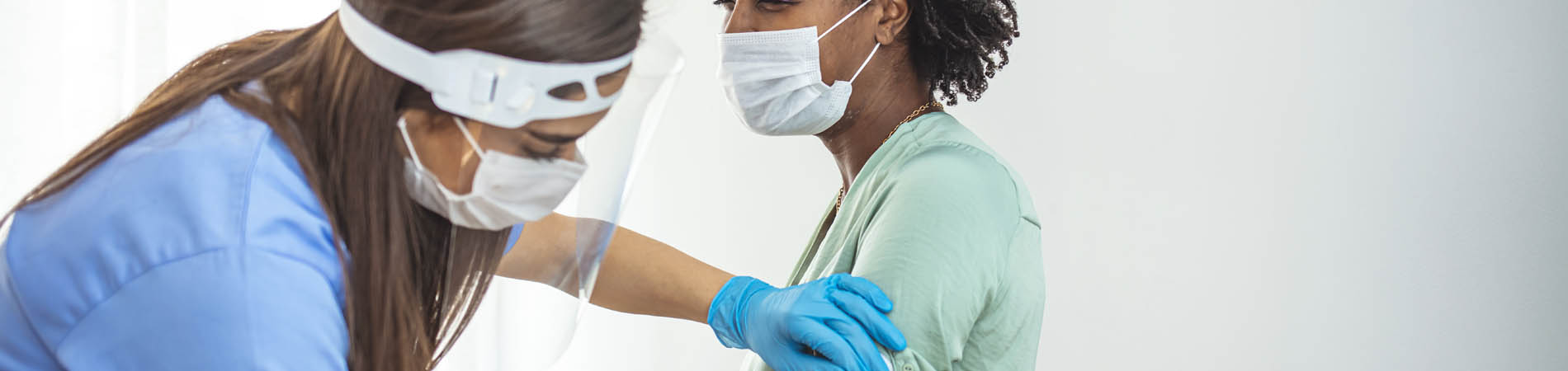 A young woman receives a vaccine from a nurse